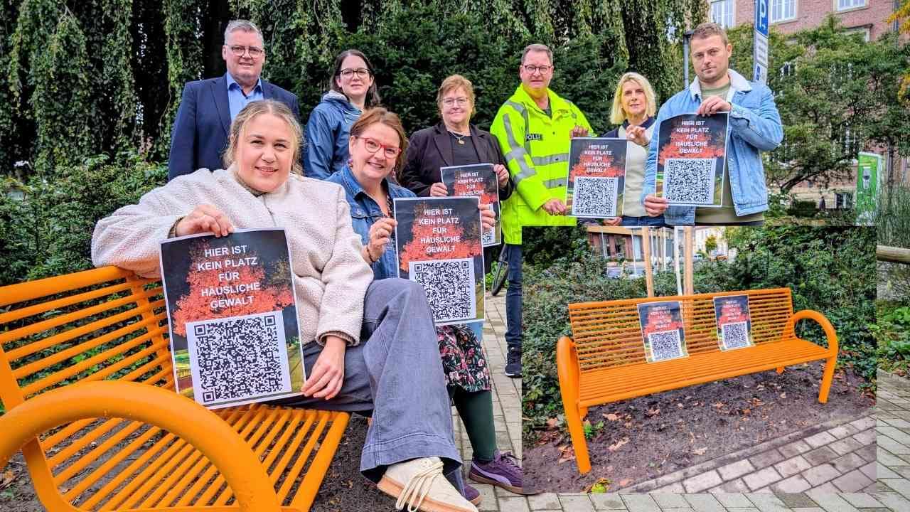Orange Bank im Freien Eine orangefarbene Bank im Freien, umgeben von Menschen, die Plakate halten.